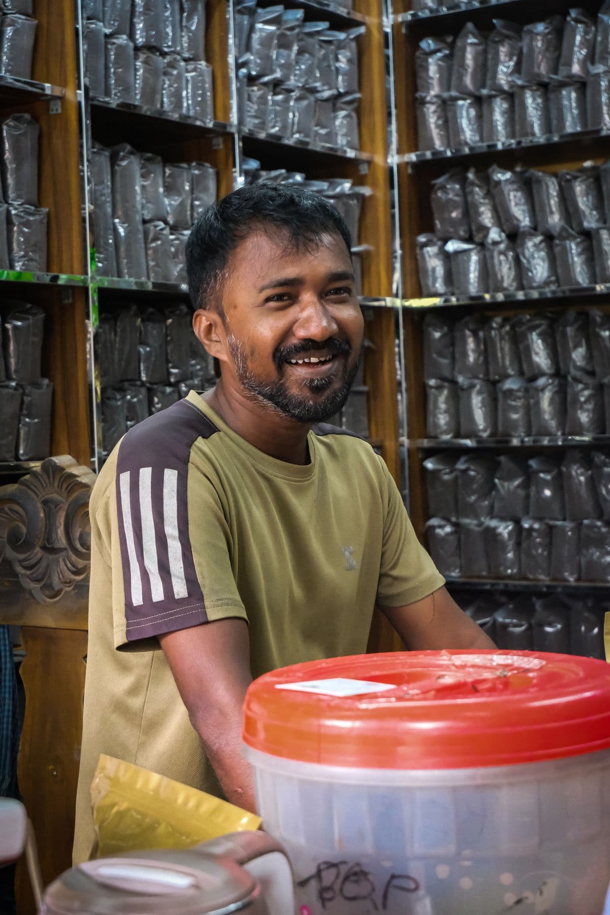A smiling Indian shop owner at his store